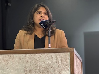 A person standing at a podium speaking into a microphone

AI-generated content may be incorrect.