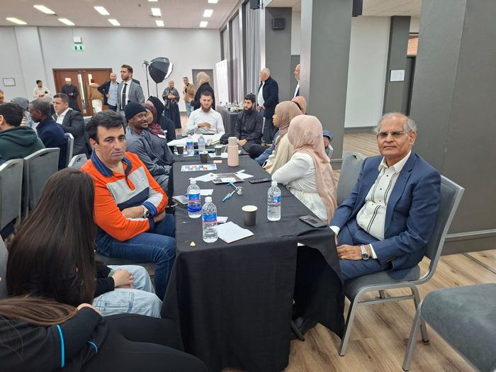 A group of people sitting at a table

AI-generated content may be incorrect.