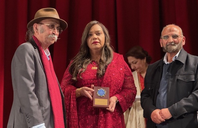 A person holding a plaque with a person standing next to a person

AI-generated content may be incorrect.