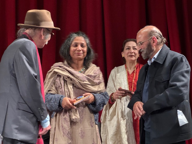 A group of people standing in front of a red curtain

AI-generated content may be incorrect.