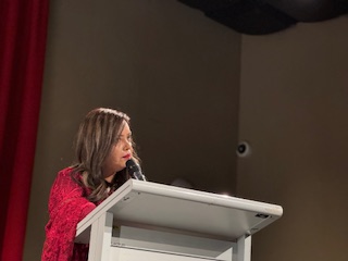 A person speaking into a microphone

AI-generated content may be incorrect.