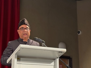 A person standing at a podium with microphones

AI-generated content may be incorrect.