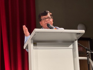 A person speaking into a microphone

AI-generated content may be incorrect.