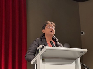 A person standing at a podium with microphones

AI-generated content may be incorrect.