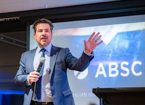 A person in a suit and tie speaking into a microphone

AI-generated content may be incorrect.