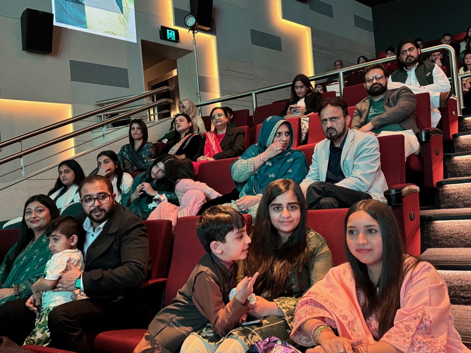 A group of people sitting in a theater

AI-generated content may be incorrect.