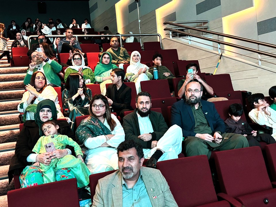 A group of people sitting in a theater

AI-generated content may be incorrect.