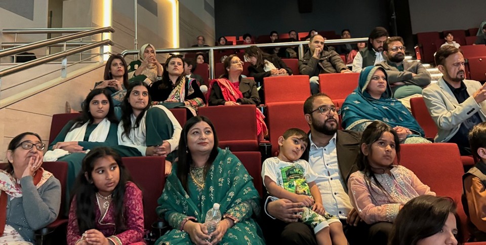 A group of people sitting in a theater

AI-generated content may be incorrect.