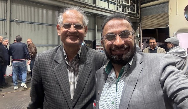 Two men wearing suits and smiling

AI-generated content may be incorrect.