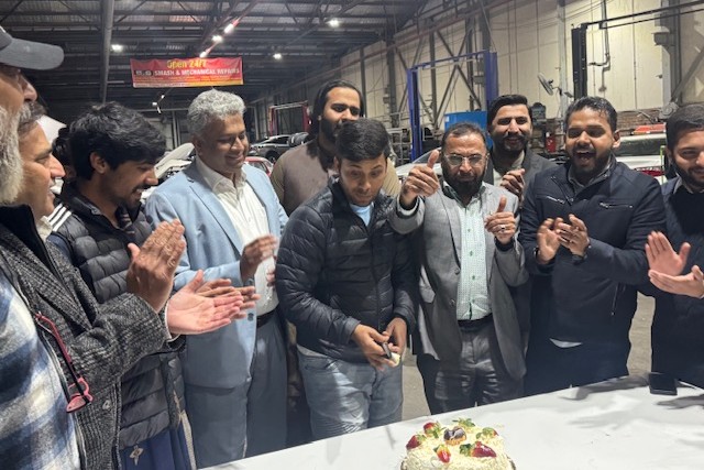 A group of men standing around a table with a cake

AI-generated content may be incorrect.