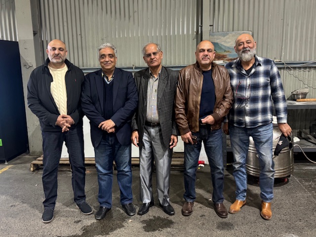 A group of men standing in a garage

AI-generated content may be incorrect.