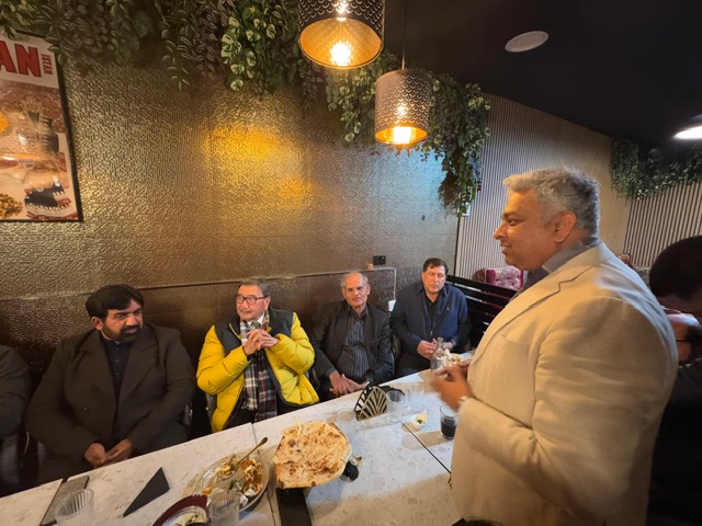 A person standing in front of a group of people sitting at a table

AI-generated content may be incorrect.