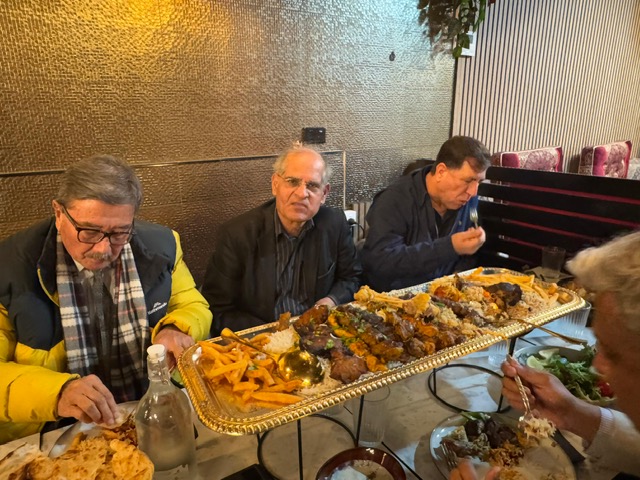 A group of men sitting at a table with food

AI-generated content may be incorrect.