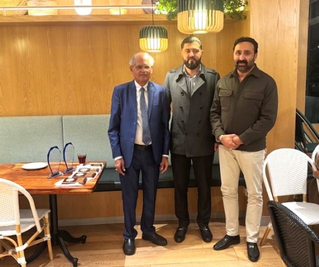 A group of men standing in a room

AI-generated content may be incorrect.