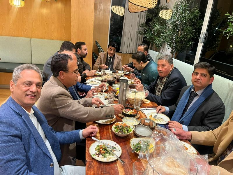 A group of men sitting at a table eating food

AI-generated content may be incorrect.