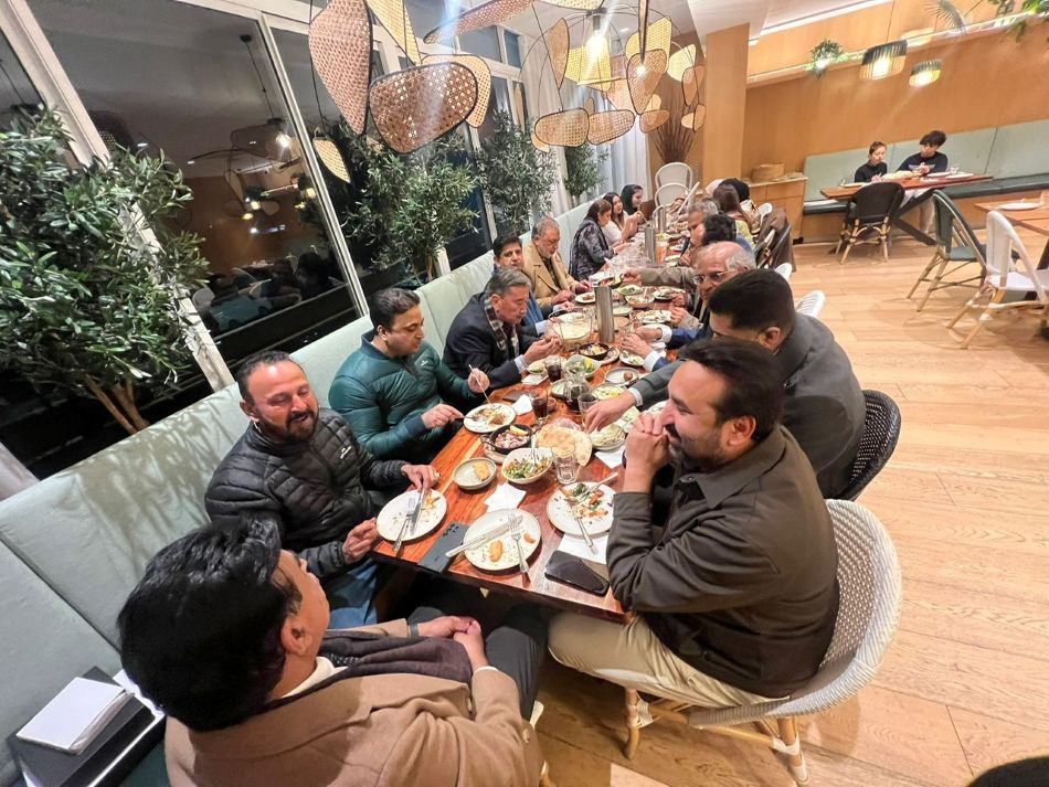 A group of people sitting at a table eating

AI-generated content may be incorrect.