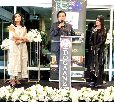 A person standing on a stage with a microphone and people standing behind him

AI-generated content may be incorrect.