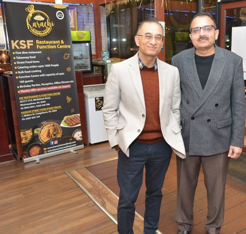 Two men standing in front of a sign

AI-generated content may be incorrect.