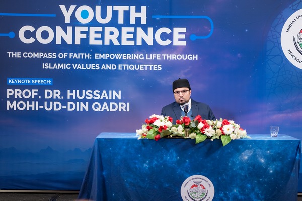 A person sitting at a podium with flowers

AI-generated content may be incorrect.