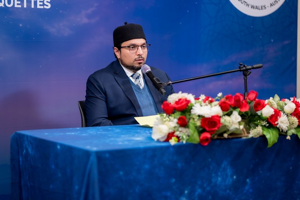 A person sitting at a table with a microphone

AI-generated content may be incorrect.