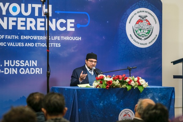 A person standing at a podium with a microphone and flowers

AI-generated content may be incorrect.