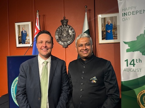 Two men standing in front of flags

AI-generated content may be incorrect.