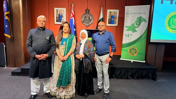 A group of people standing in front of a flag

AI-generated content may be incorrect.