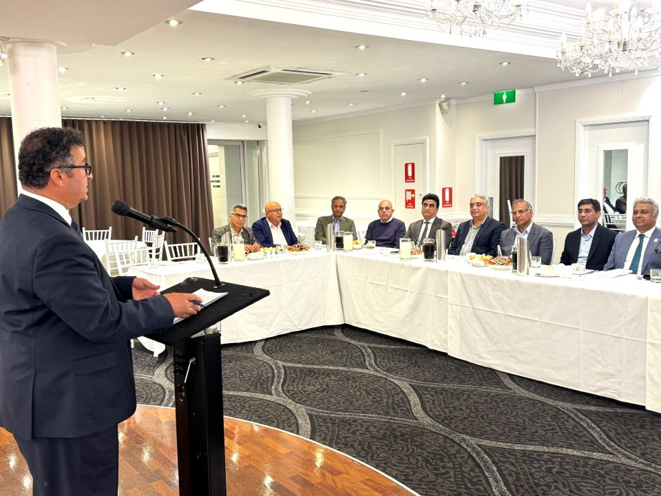 A person standing at a podium with a group of people in the background

AI-generated content may be incorrect.