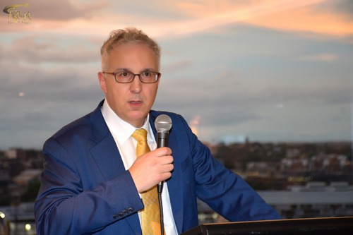 A person in a suit speaking into a microphone

AI-generated content may be incorrect.