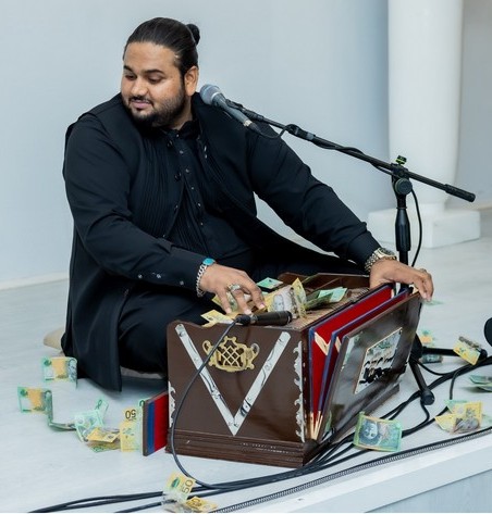 A person sitting on the floor with a microphone and money in it

AI-generated content may be incorrect.