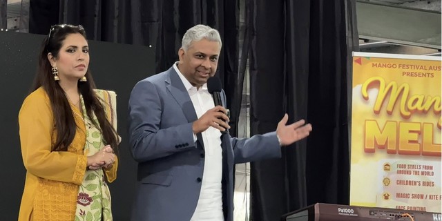 A person in a suit holding a microphone

AI-generated content may be incorrect.