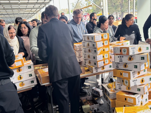 A group of people standing around a table with boxes

AI-generated content may be incorrect.