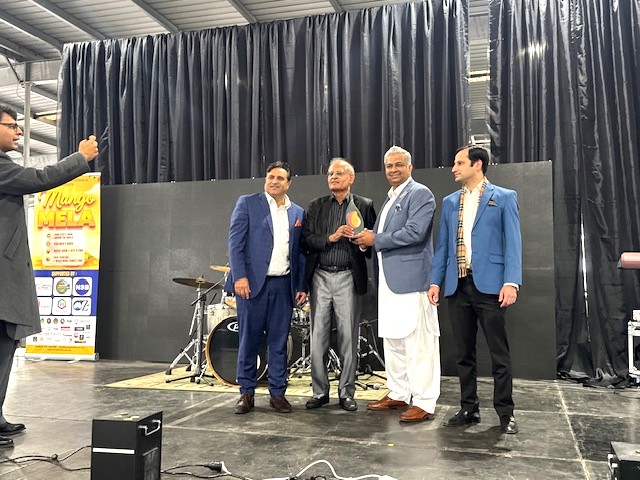 A group of men standing on a stage

AI-generated content may be incorrect.