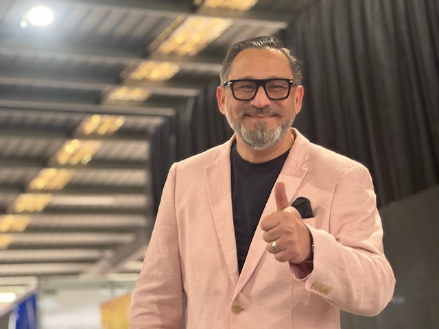 A person in a pink suit giving a thumbs up

AI-generated content may be incorrect.