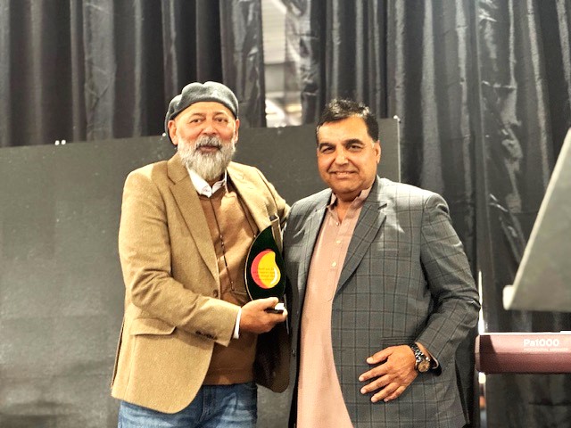 Two men standing together holding a trophy

AI-generated content may be incorrect.