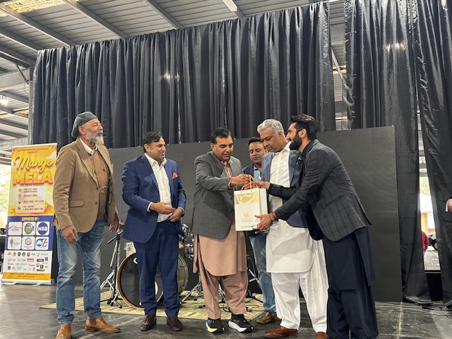 A group of men standing around a person holding a piece of paper

AI-generated content may be incorrect.