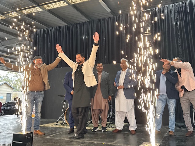 A group of men standing on a stage with fireworks

AI-generated content may be incorrect.