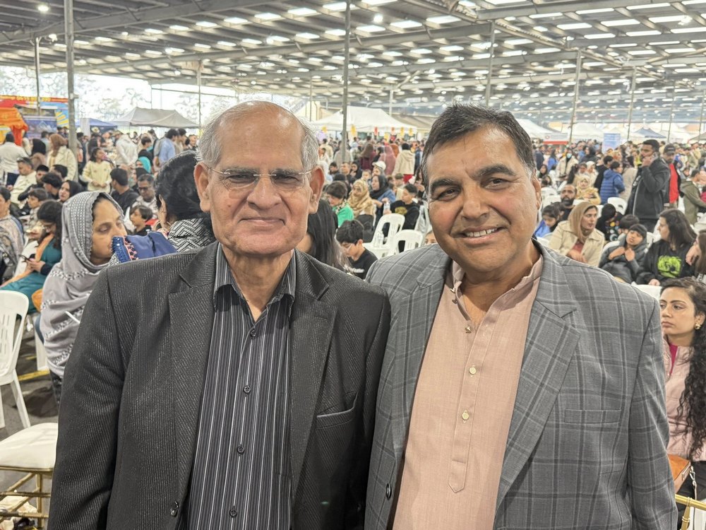 Two men standing together in front of a large crowd

AI-generated content may be incorrect.