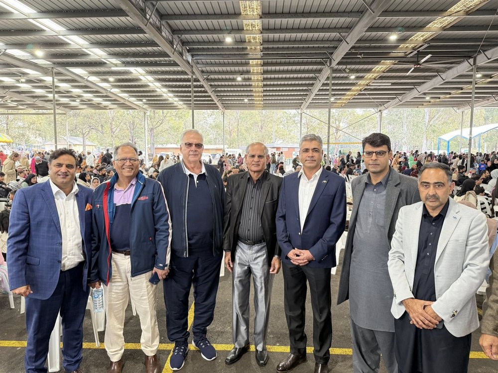 A group of men standing together in a room with a large crowd

AI-generated content may be incorrect.