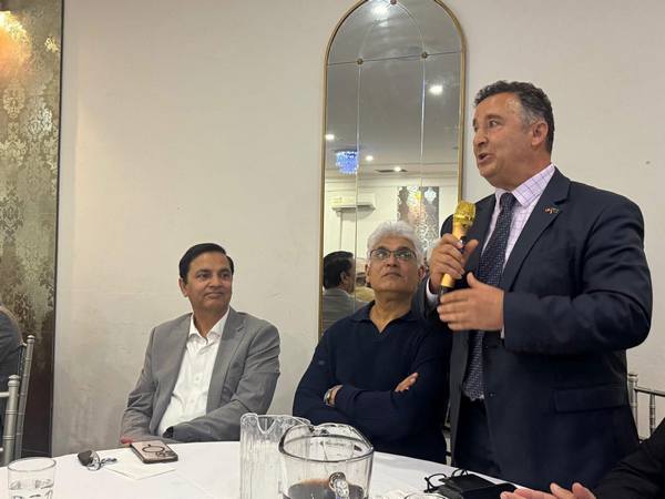 A person in a suit holding a microphone

AI-generated content may be incorrect.