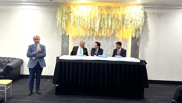 A person standing in front of a table with a group of men

AI-generated content may be incorrect.