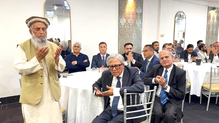 A person standing in front of a group of men

AI-generated content may be incorrect.