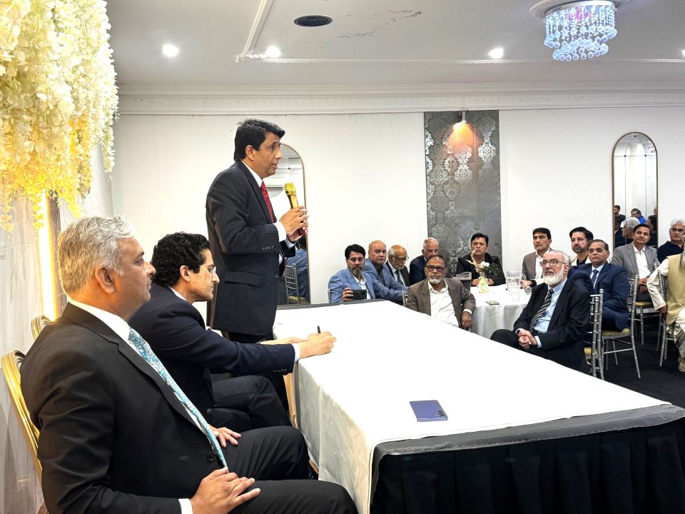 A person standing in front of a group of men sitting at a table

AI-generated content may be incorrect.