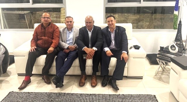 A group of men sitting on a couch

AI-generated content may be incorrect.