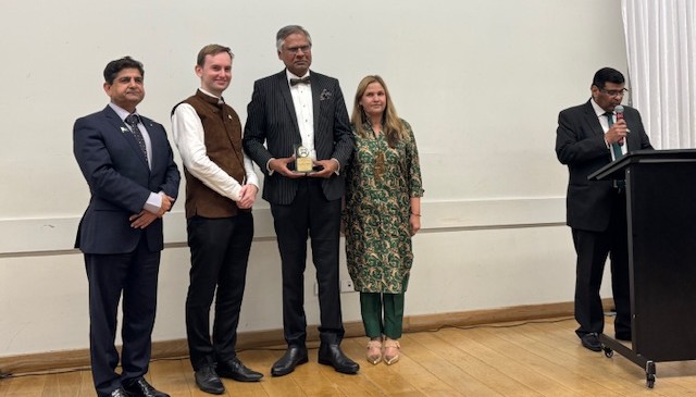 A group of people standing in front of a white wall

AI-generated content may be incorrect.