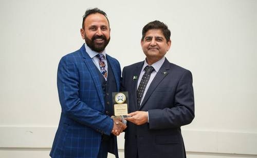 Two men shaking hands with a trophy

AI-generated content may be incorrect.