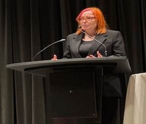 A person standing at a podium with microphones

AI-generated content may be incorrect.