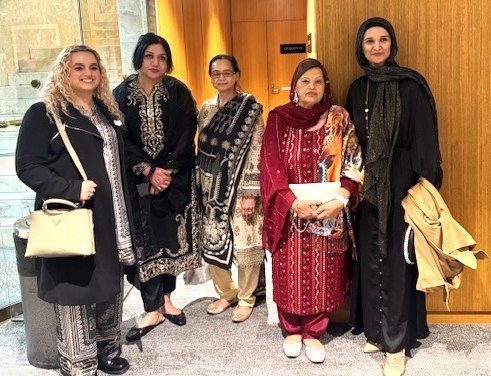 A group of women standing in front of a door

AI-generated content may be incorrect.