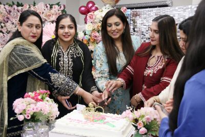 A group of women cutting a cake

AI-generated content may be incorrect.