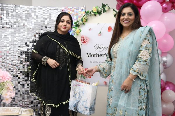 A group of women standing in front of a sign

AI-generated content may be incorrect.